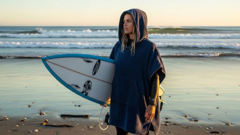 Surfer wearing a hooded surf poncho on the beach after a session