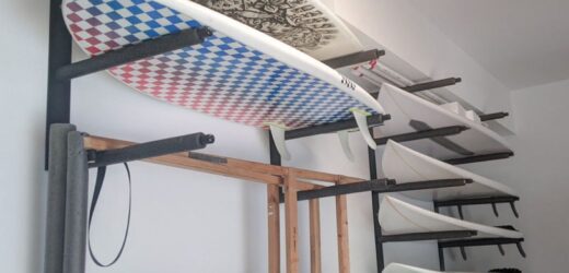 Surfboard placed on a newly installed wall rack for safe home storage