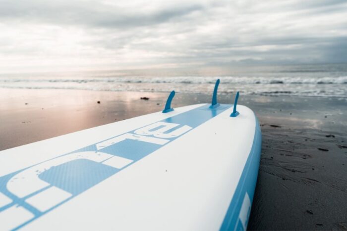 Close-up of paddle board fins being attached for better tracking and performance